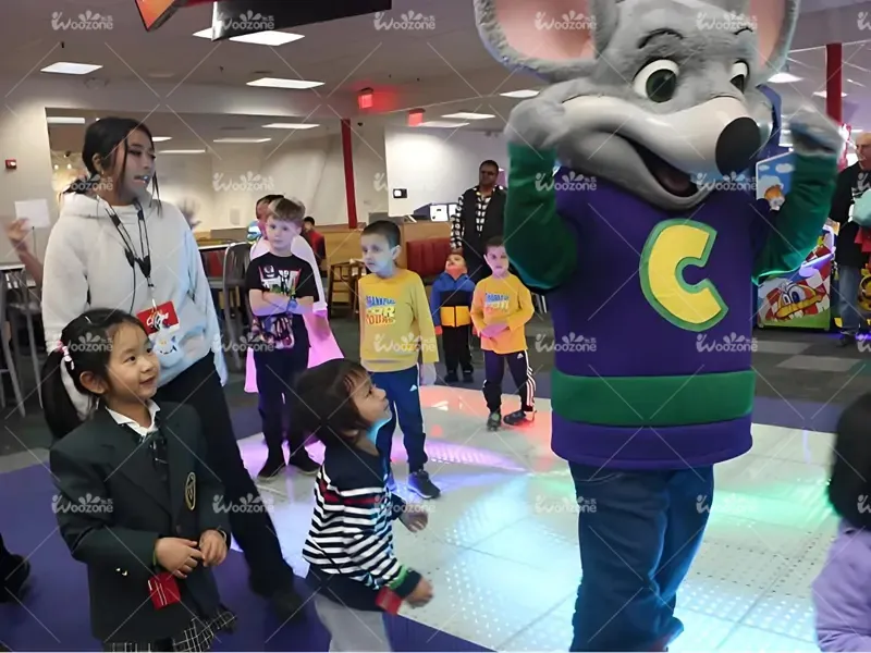 Kids interacting with mouse mascot character during party event inside family entertainment center dining area
