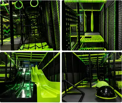 An indoor playground obstacle course integrated with slides and climbing nets at Summit Ninja Challenge family entertainment center.