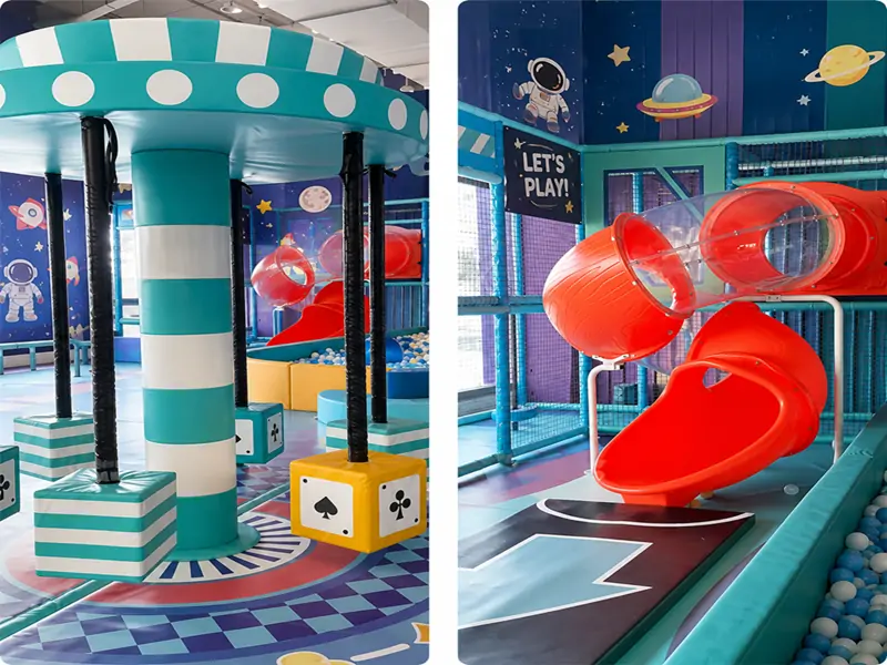 Space themed kids play gear at Little Champs Playland, including teal striped rotating soft carousel with playing card blocks and curved transparent red tunnel slide against astronaut and planet printed wall backdrop